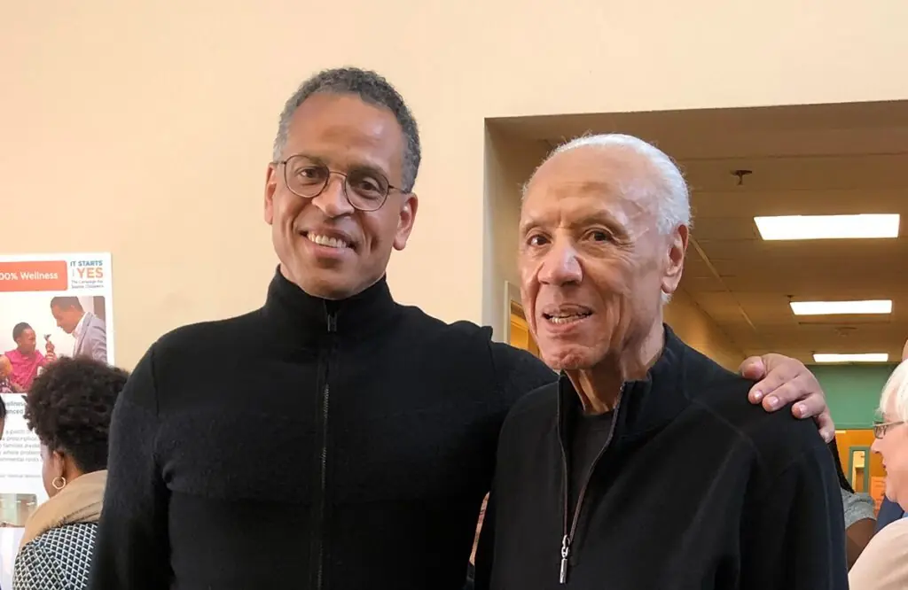 Two men, in black jackets standing for a photo. They include Dr. Ben Danielson and Coach Lenny Wilkens.